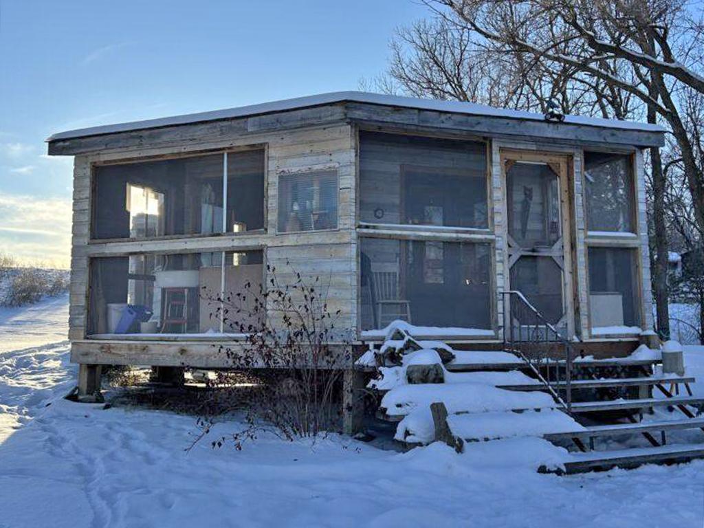 Round House in winter, steps leading to door, sun shinning through window.