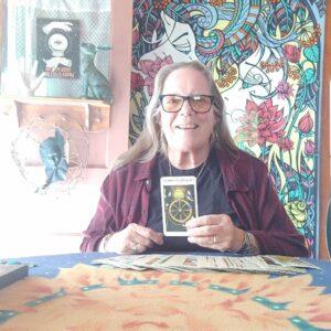 Maureen Morrish holding up a Tarot card.