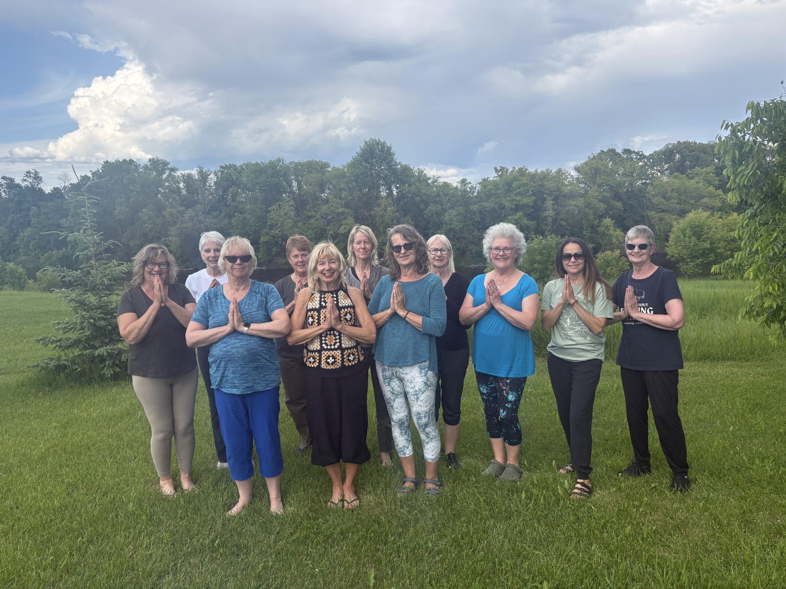 Mary Lou MacGregor and yoga group standing by the river.